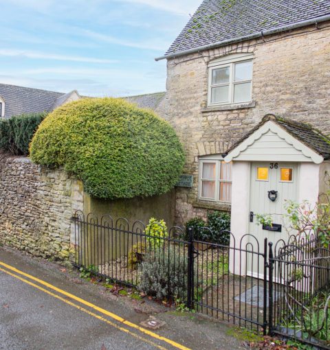 Traditional Cotswolds stone cottage with iron gate and topiary hedge managed as a holiday let by Red Kite Hosts