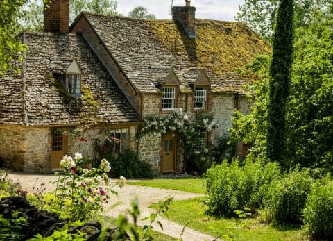 Stone cottage surrounded by gardens in the Cotswolds